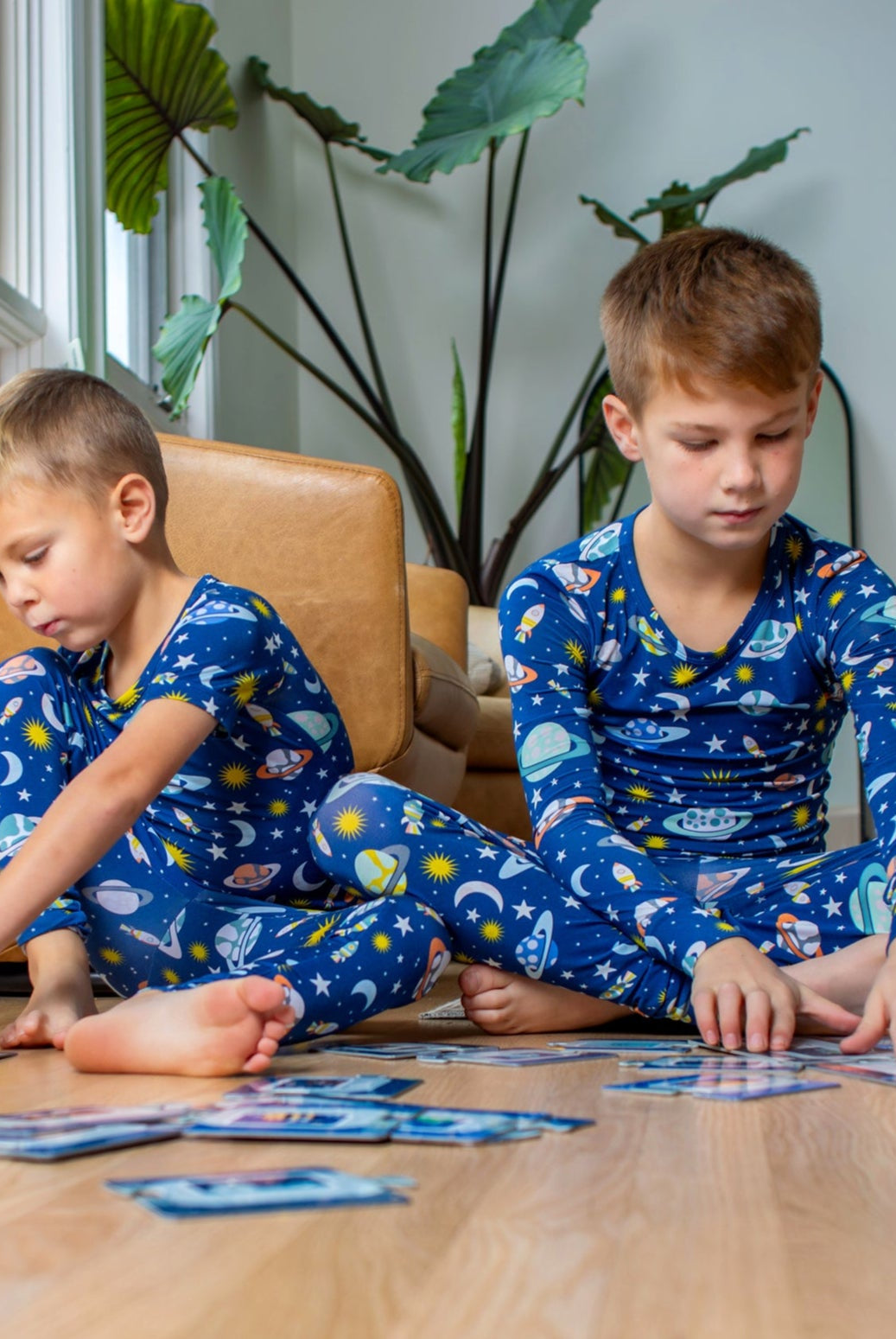 Earthly Threads space-themed two-piece pajama set, featuring a vibrant print of planets, moons, and stars, crafted from buttery soft, breathable bamboo fabric, available in short or long sleeve options for comfort during hot summer days and cold winter nights.