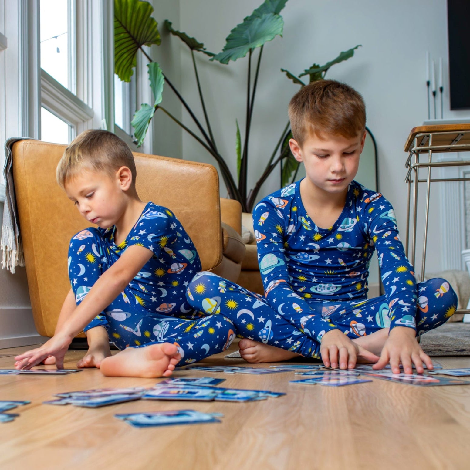 Earthly Threads space-themed two-piece pajama set, featuring a vibrant print of planets, moons, and stars, crafted from buttery soft, breathable bamboo fabric, available in short or long sleeve options for comfort during hot summer days and cold winter nights.