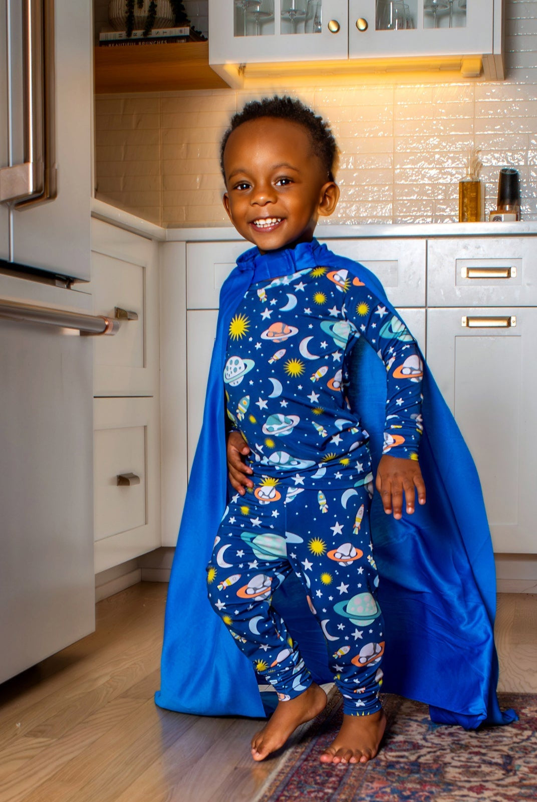 Galaxy-inspired kids' pajamas with a playful planets and spaceships print, designed for cozy, breathable sleep in a buttery-soft, hypoallergenic bamboo blend.