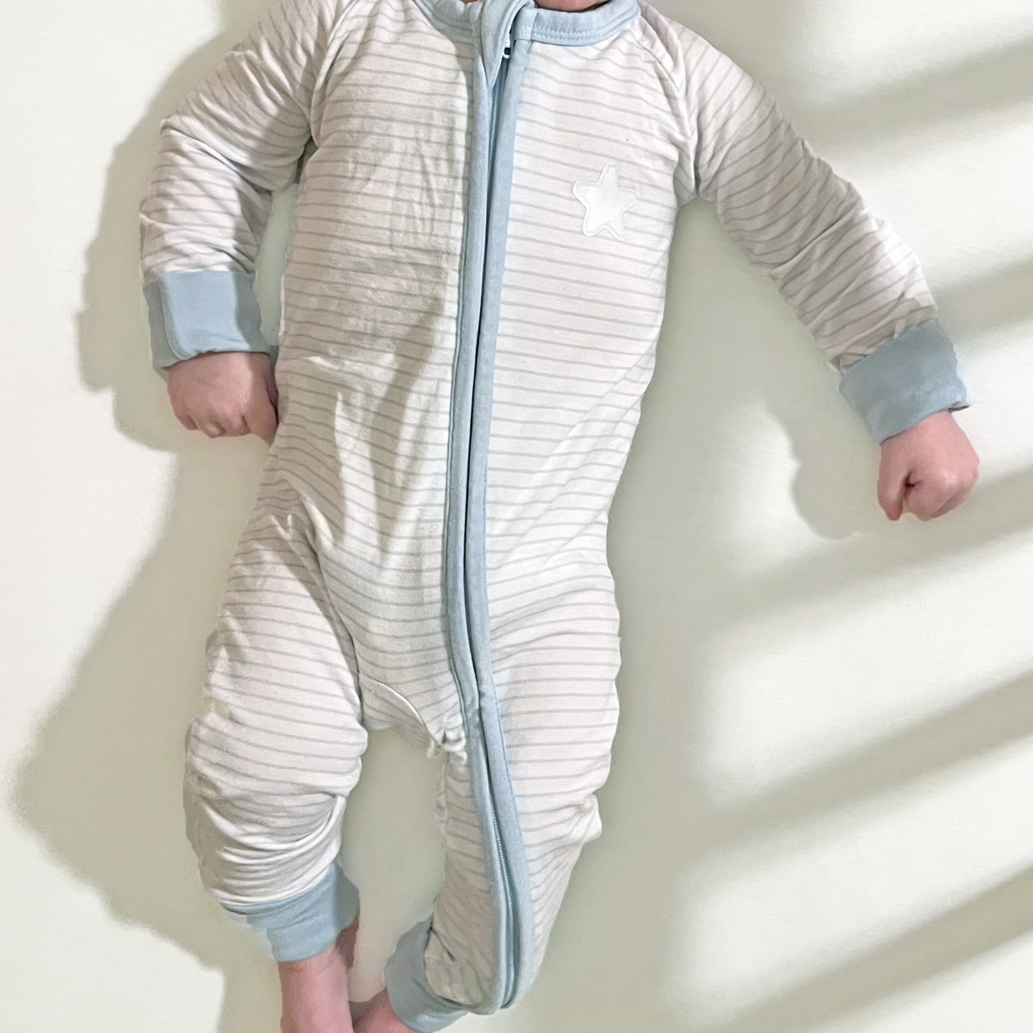 Super soft snuggles in a classic blue and white strip with celestial details. Perfect neutral bamboo dual zip sleeper with fold-over cuffs that grows with your baby.