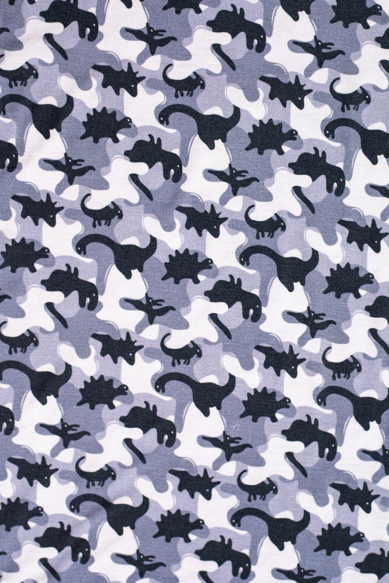 Earthly Threads kids' bamboo pajamas featuring a fun camo dinosaur print in gray, black, and white.