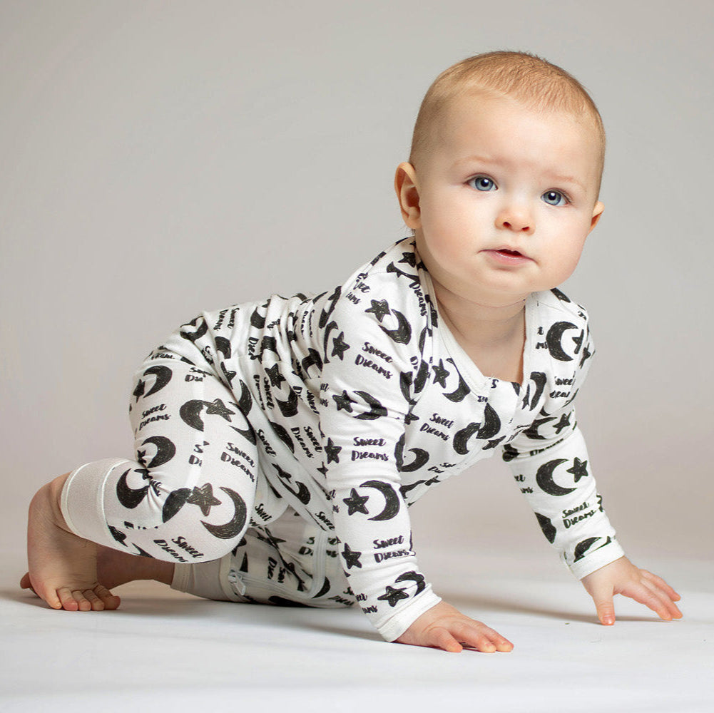 Sweet Dreams bamboo zip romper with a celestial pattern of stars, moons, and soft "Sweet Dreams" lettering for a cozy night’s sleep.