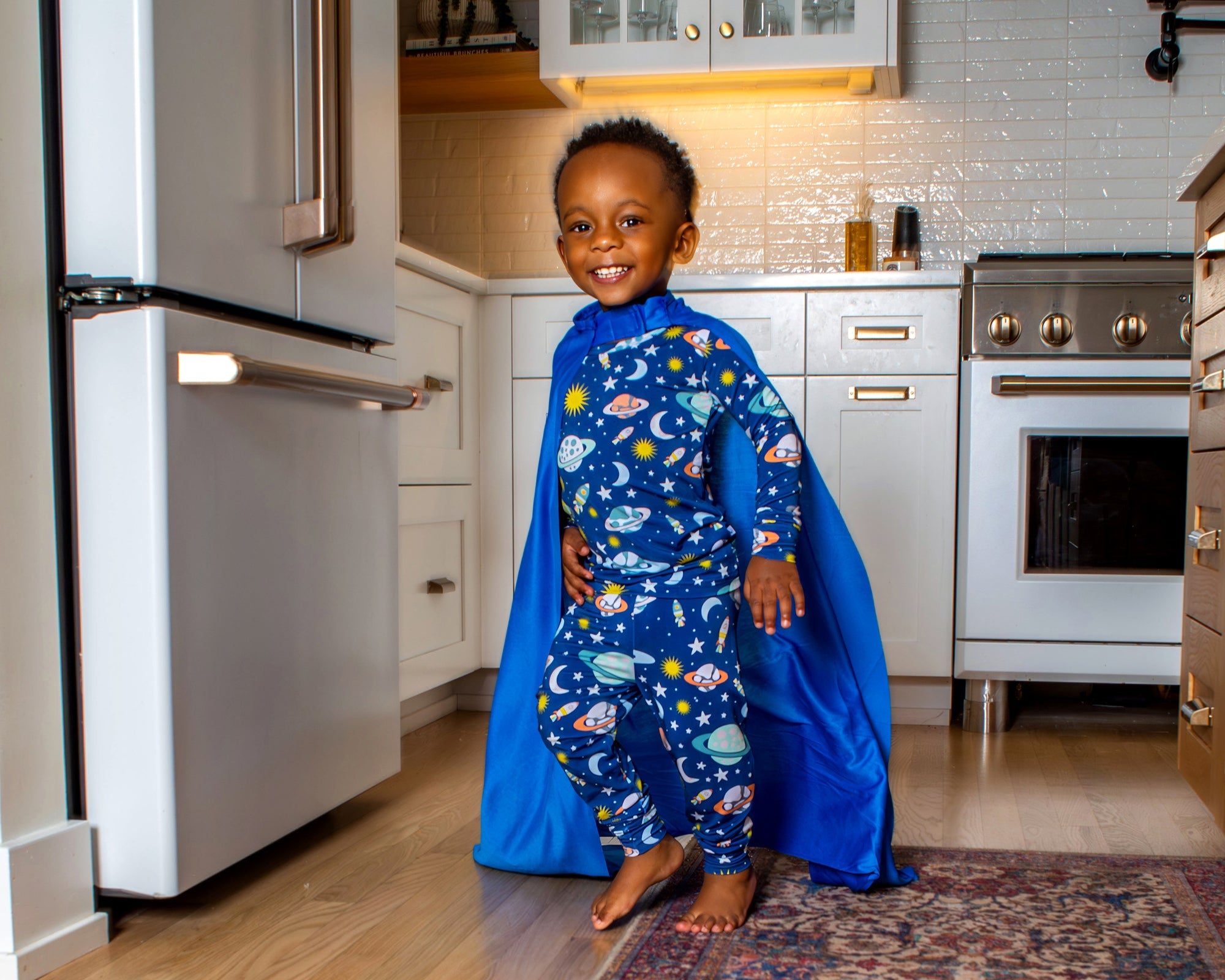 Galaxy-inspired kids' pajamas with a playful planets and spaceships print, designed for cozy, breathable sleep in a buttery-soft, hypoallergenic bamboo blend.