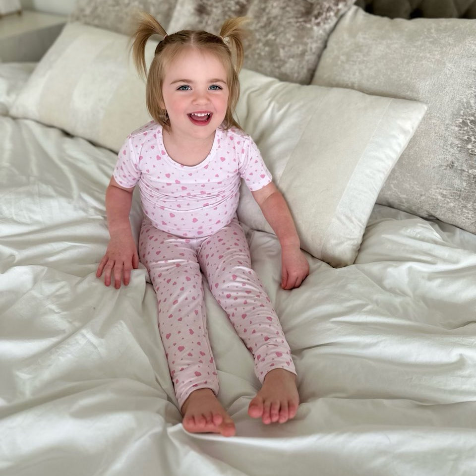 Earthly Threads bamboo pajama set for kids, featuring an adorable pink heart pattern on a soft, breathable fabric.