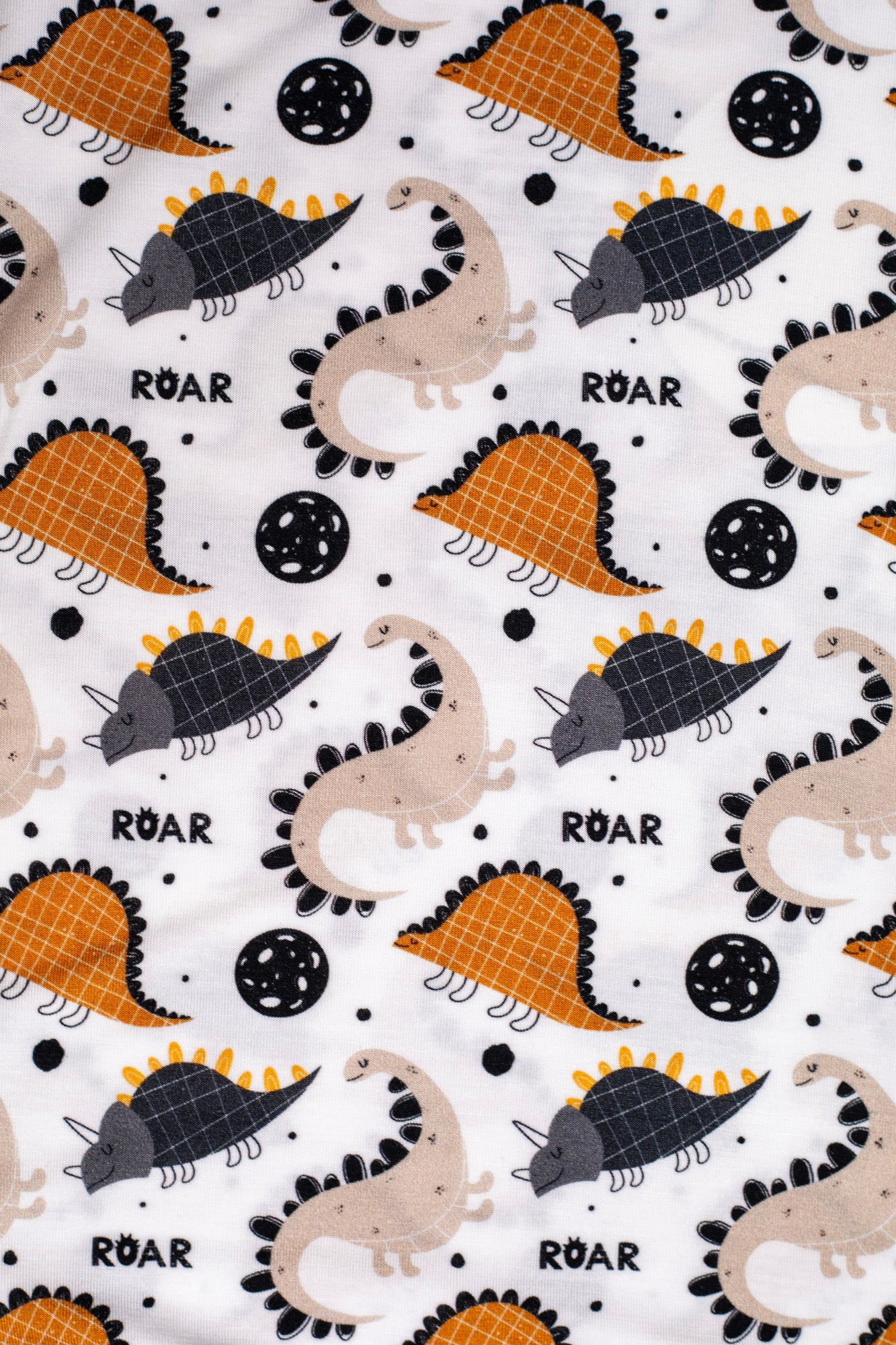 Ultra-soft and hypoallergenic bamboo pajamas with a cute dinosaur print and "ROAR" lettering, designed for warmth, breathability, and bedtime fun.