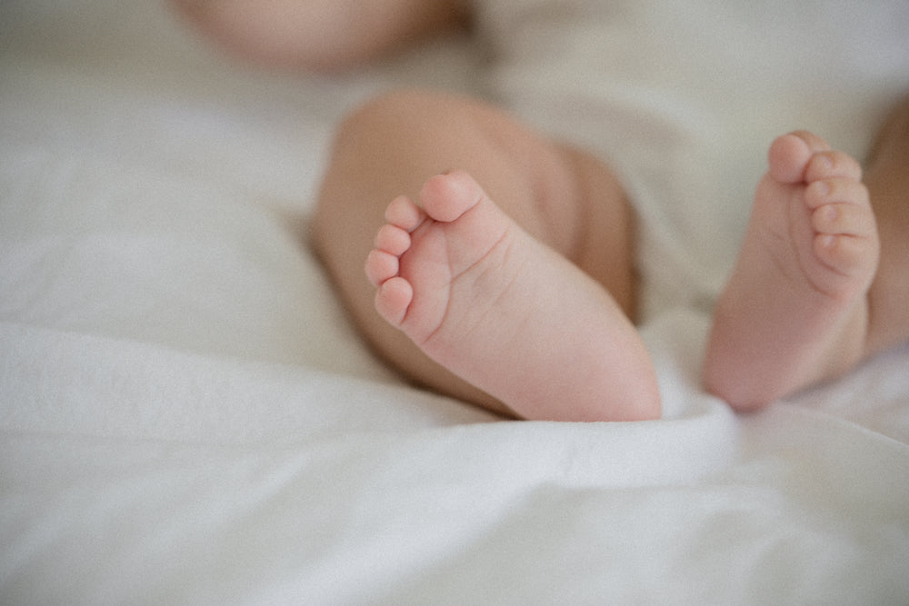 small-feet-of-a-baby-on-a-white-sheet